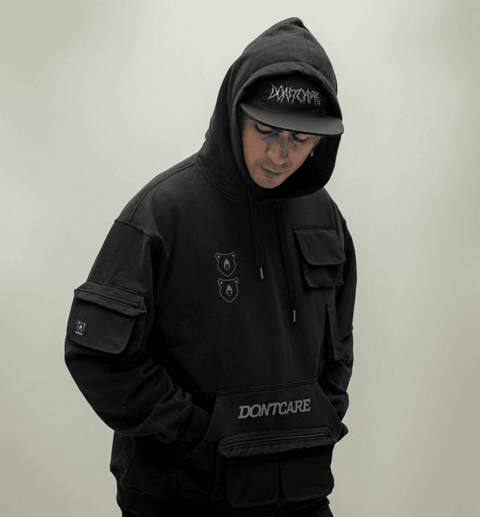 Ropa urbana. Modelo vistiendo buzo negro con capucha y gorra de la marca Dontcare, representando el estilo urbano y alternativo de la marca.