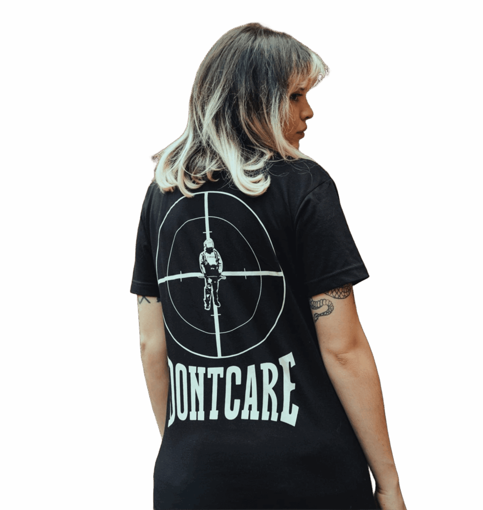 Modelo de espaldas con camiseta negra Dontcare estampada en la parte trasera, destacando el carácter irreverente de la marca.
